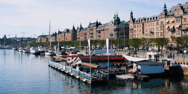 Strandbryggan's floating restaurant along the quay at Strandvägen in Stockholm, with moored boats and grand stone buildings, easy to reach by boat