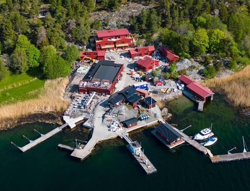 Harbour on Nämdö with red buildings, jetties and moored boats, seen from above, in the Stockholm archipelago