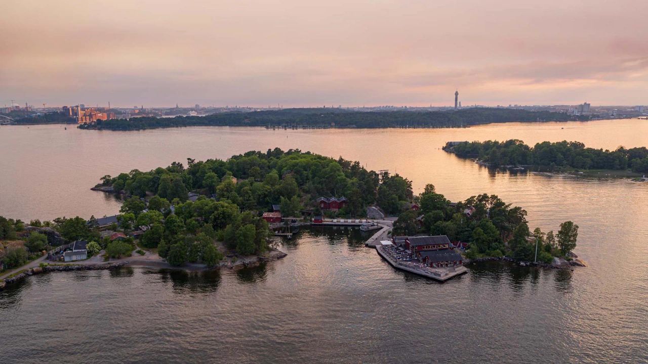 Aerial view of Fjäderholmarna at dusk, with the Stockholm skyline on the horizon