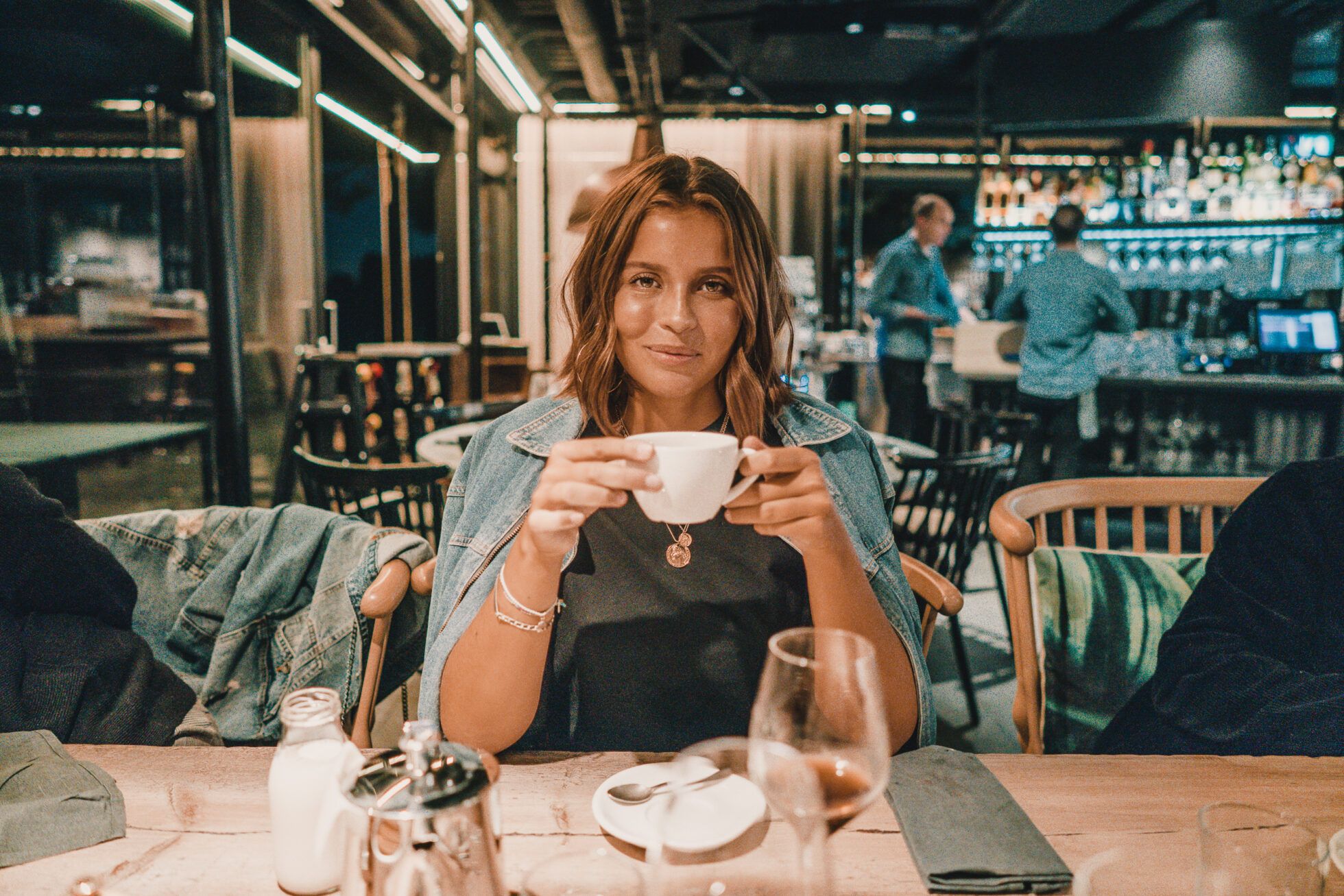 Guest holding a coffee cup in the bar and dining room at The Old Smokehouse