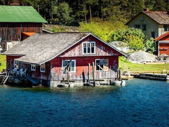 Red wooden boathouse at the water's edge on Ingmarsö in the Stockholm archipelago
