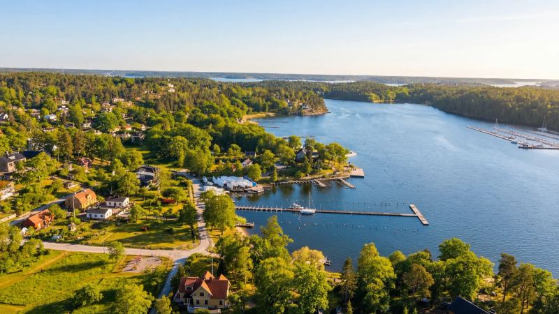 Aerial view of a wooded shoreline, bay and jetties around The Old Smokehouse