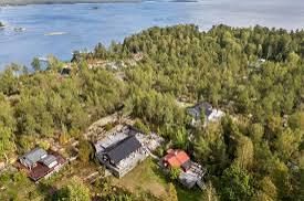 Aerial view of houses among forest by the water on Blidö in the Stockholm archipelago