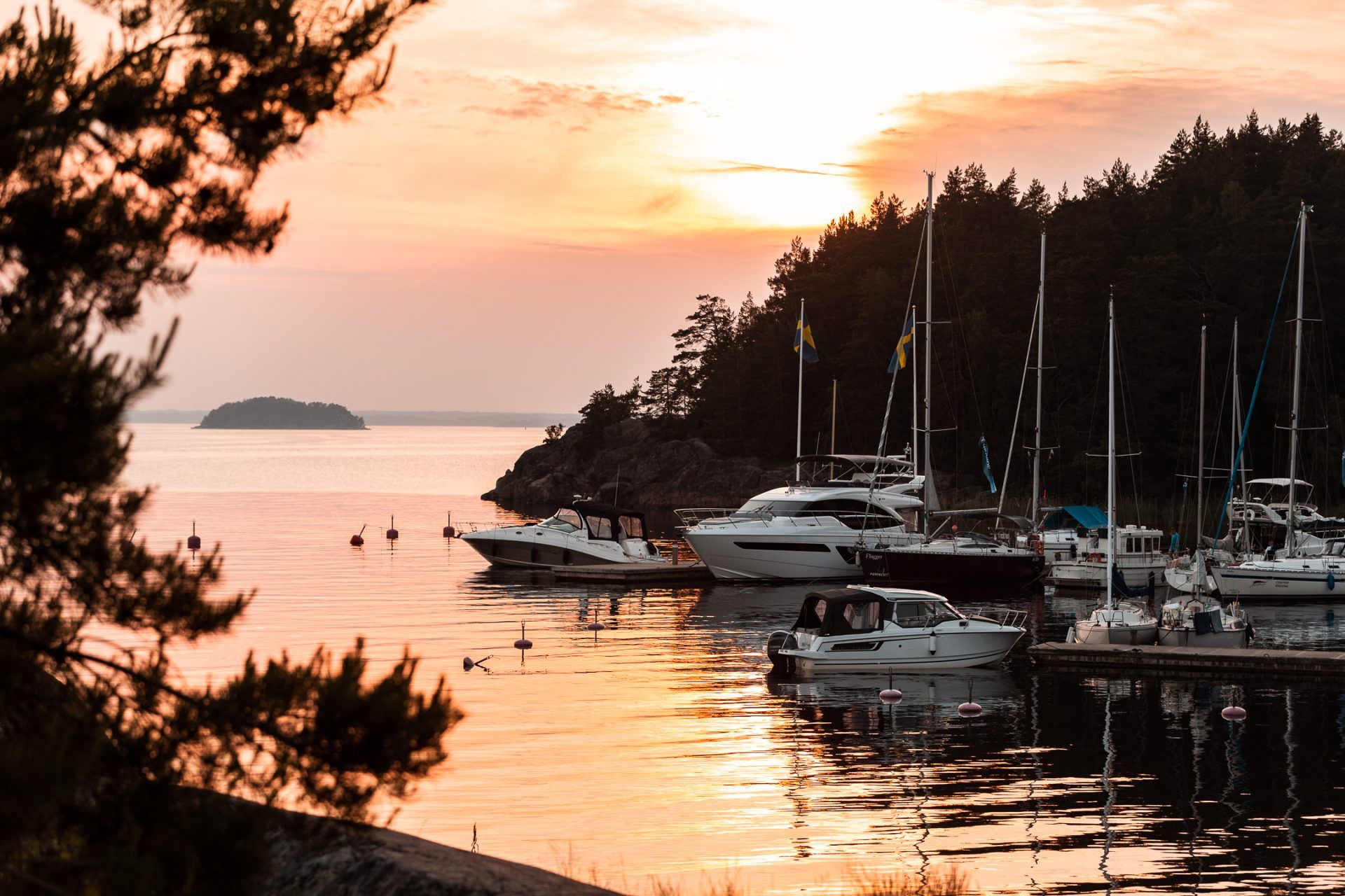Sunset over moored sailboats and motorboats in a bay on Grinda