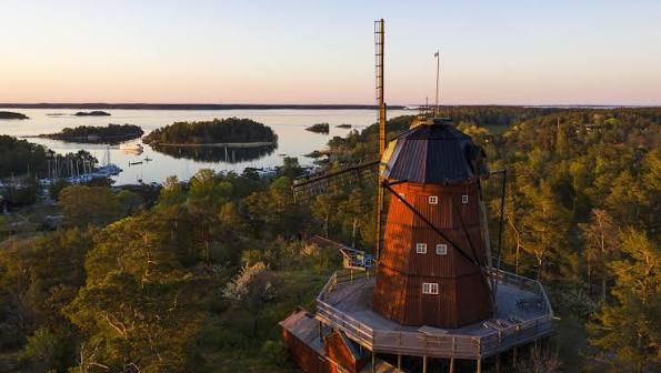 Wooden windmill on Utö at sunset, overlooking forest and archipelago islands