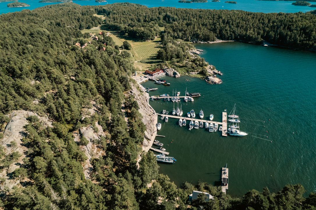Grinda from above – guest harbour with moored boats beside pine forest and granite cliffs