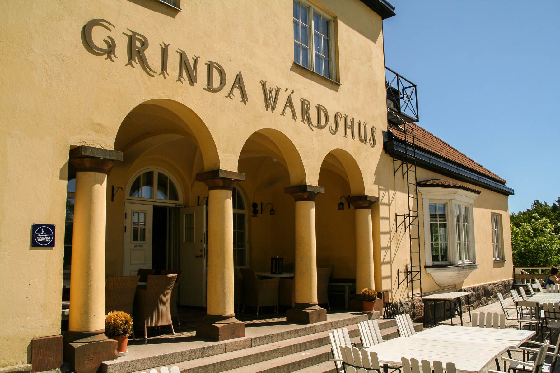 Arched entrance of Grinda Wärdshus with the inn's name above the colonnade