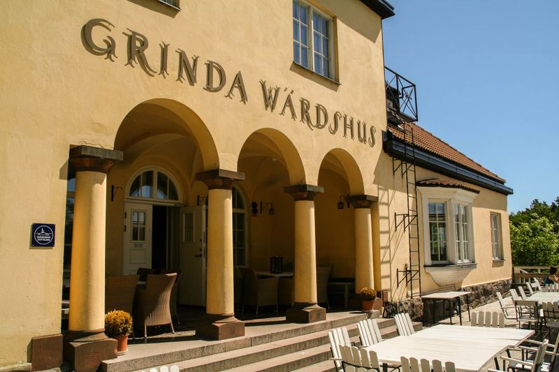 Arched entrance of Grinda Wärdshus with the inn's name above the colonnade