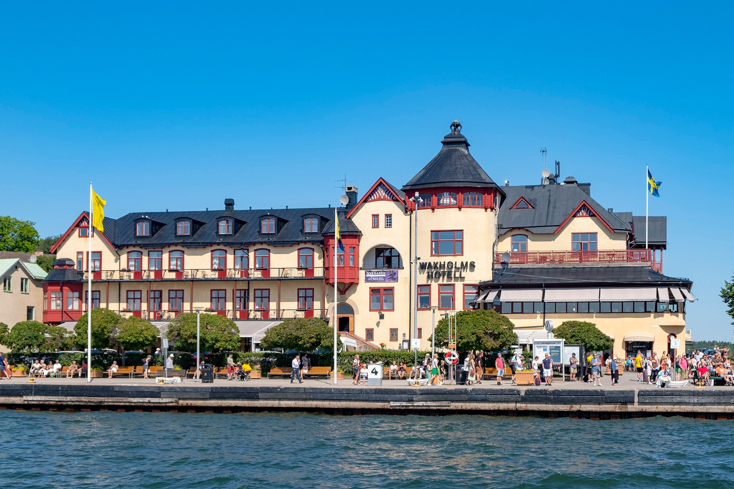 The waterfront hotel and promenade in Vaxholm, with Swedish flags flying