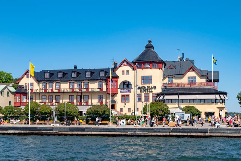 The waterfront hotel and promenade in Vaxholm, with Swedish flags flying