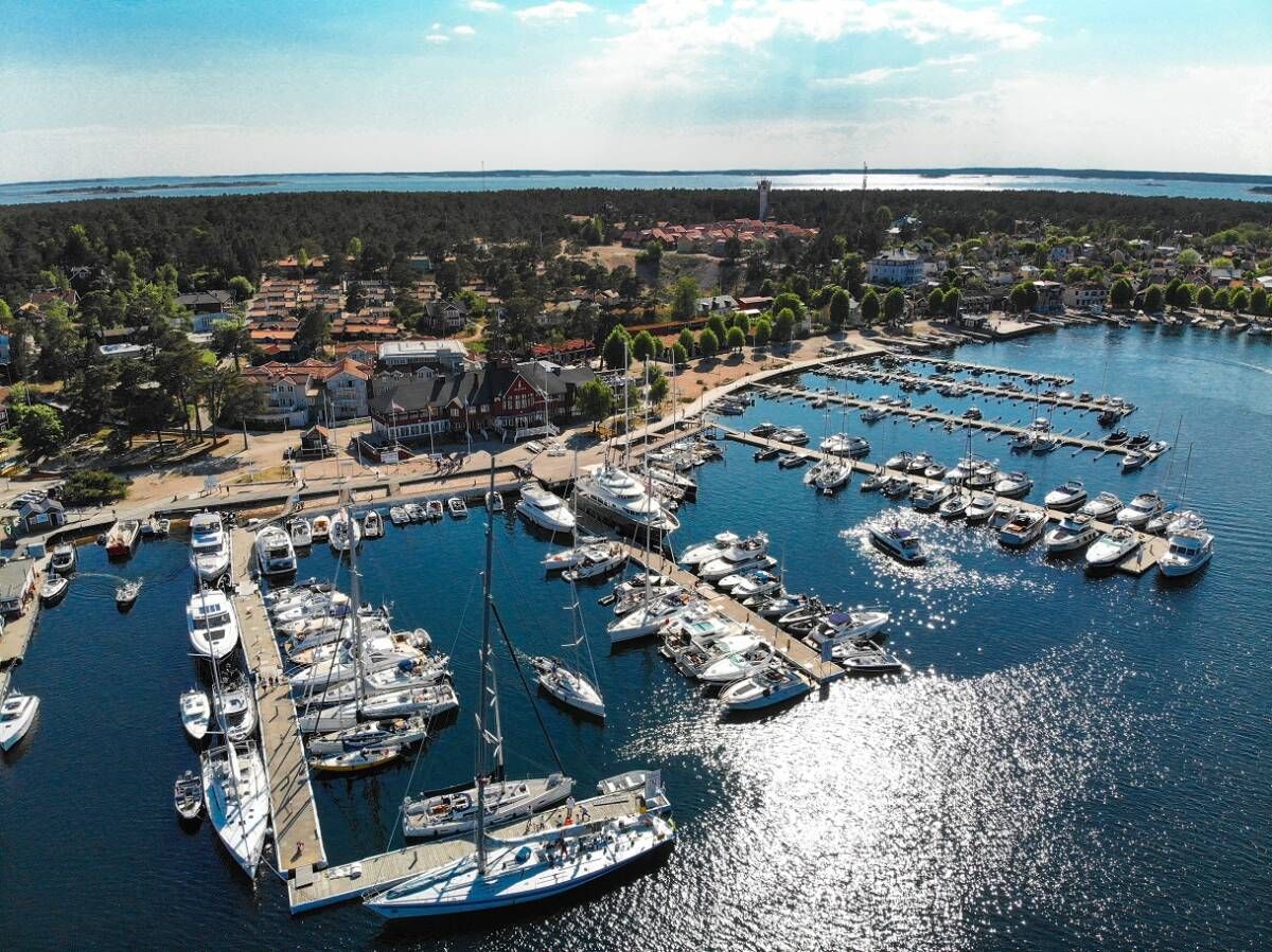 Sandhamn harbour from above, with boats moored along long jetties