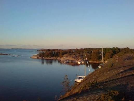 Sailing boats moored in a calm bay at sunset near Harö in the Stockholm archipelago