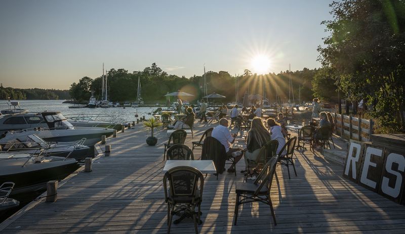 Guests on the waterfront deck at sunset at The Old Smokehouse