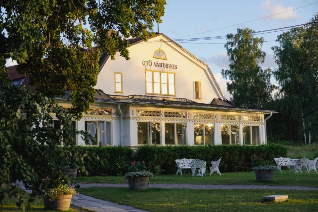 Utö Värdshus, a white wooden inn with a glazed veranda and garden