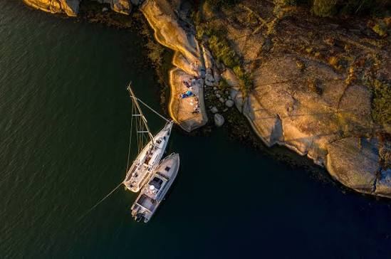 Two sailing boats moored against smooth granite rocks at Nämdö in the Stockholm archipelago, seen from above