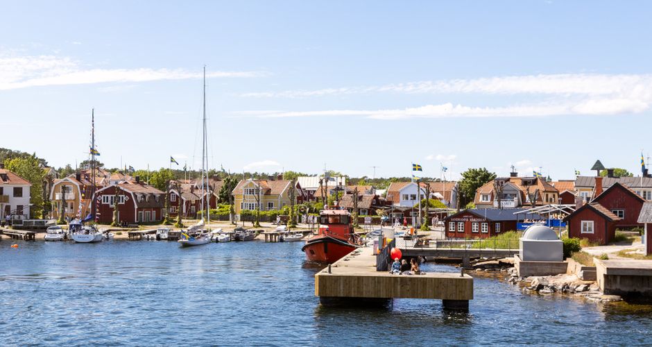 Sandhamn village seen from the water, with red and yellow wooden houses and jetties