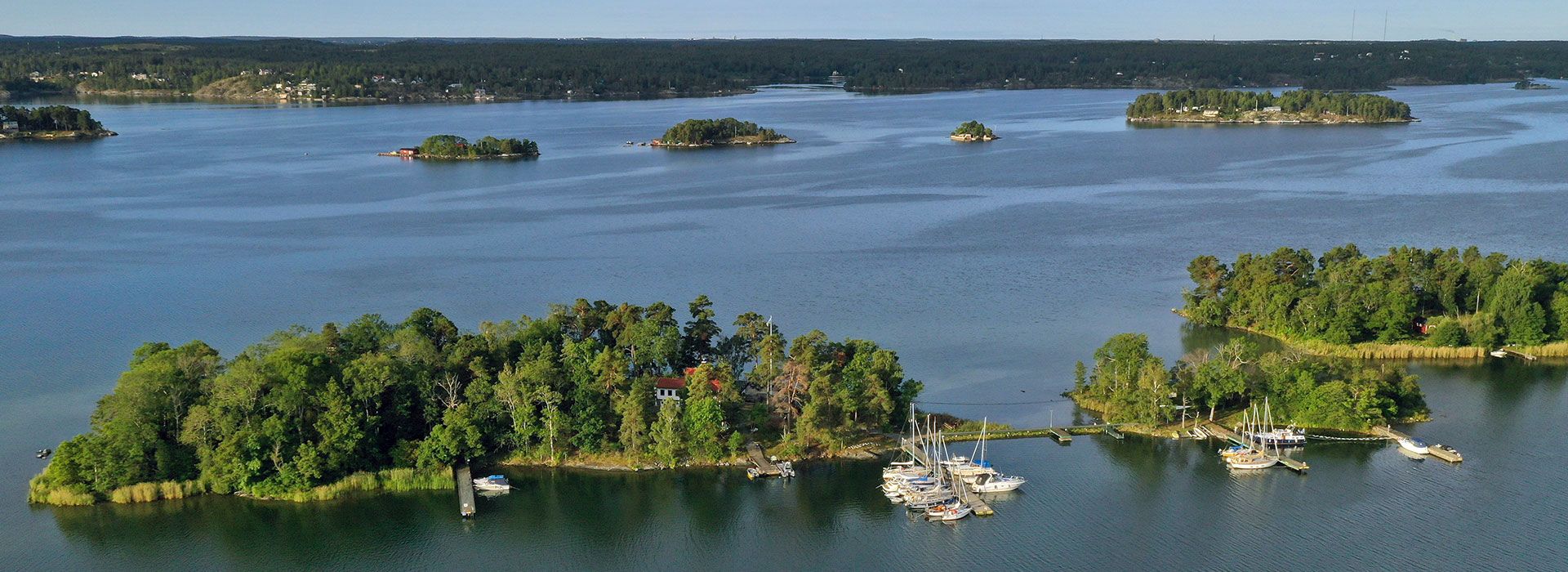 Aerial view of wooded islands and moored sailboats around Getfoten in the Stockholm archipelago