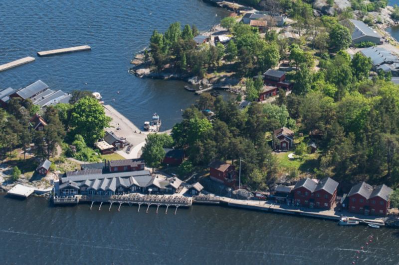 Aerial view of Fjäderholmarna's jetties, red wooden houses and greenery