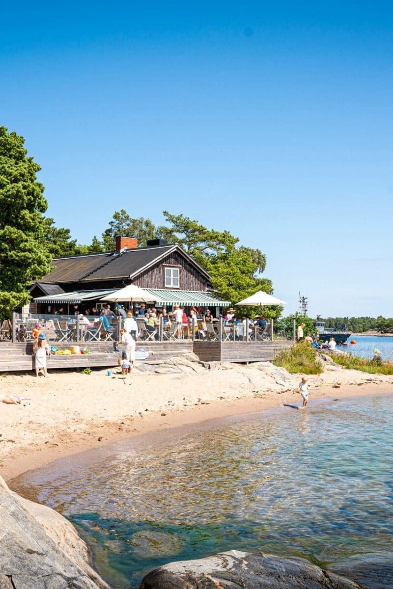 Sandy beach and waterside restaurant terrace with parasols on Idöborg