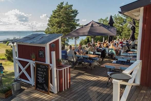 Guests on an outdoor restaurant terrace with parasols on Nåttarö in the Stockholm archipelago