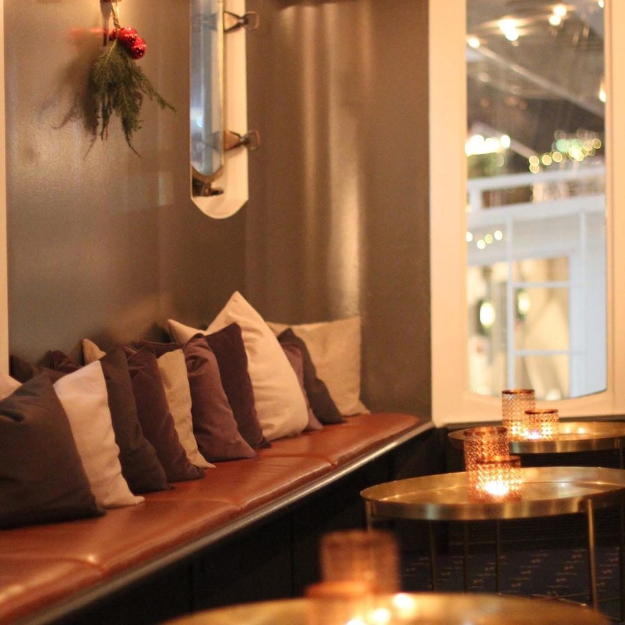 Candlelit lounge with cushions and brass tables on board Teaterskeppet in Stockholm